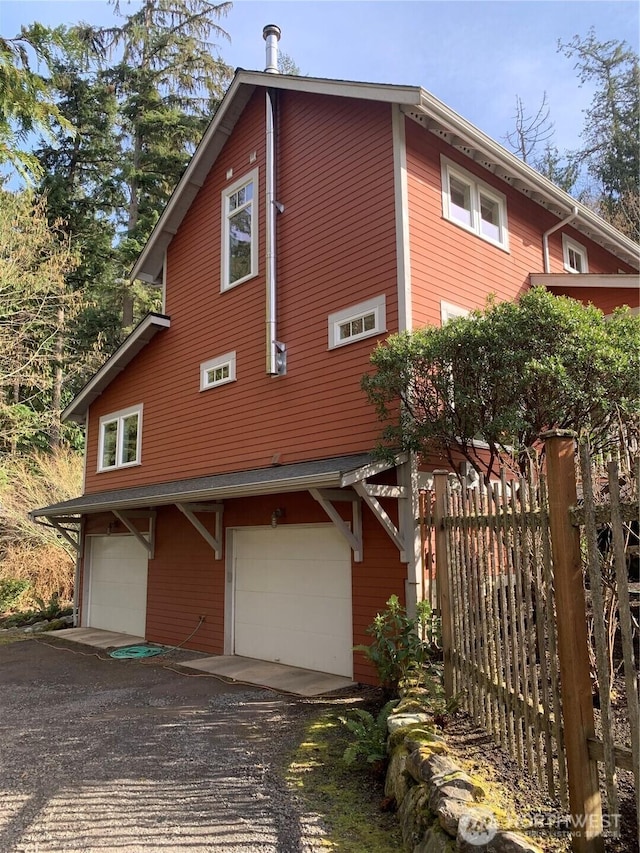 view of front of home with a garage and fence