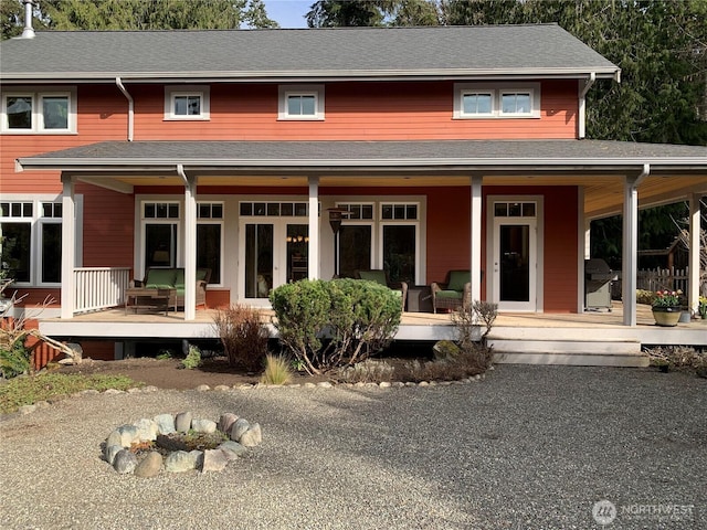 view of front facade with covered porch and roof with shingles