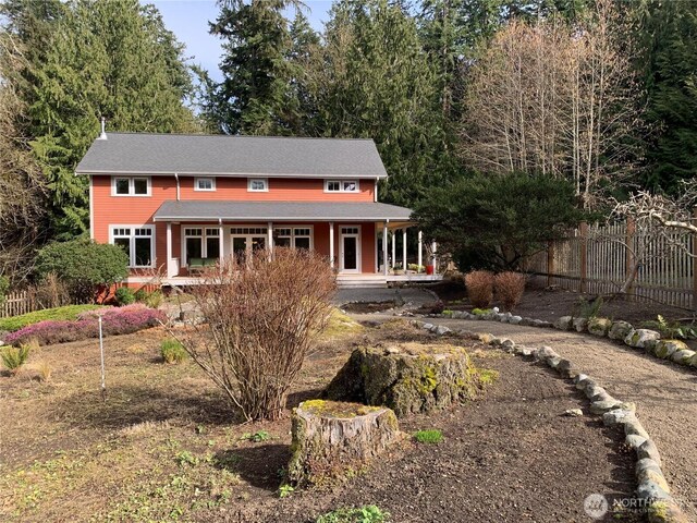 view of front of home featuring fence and a porch