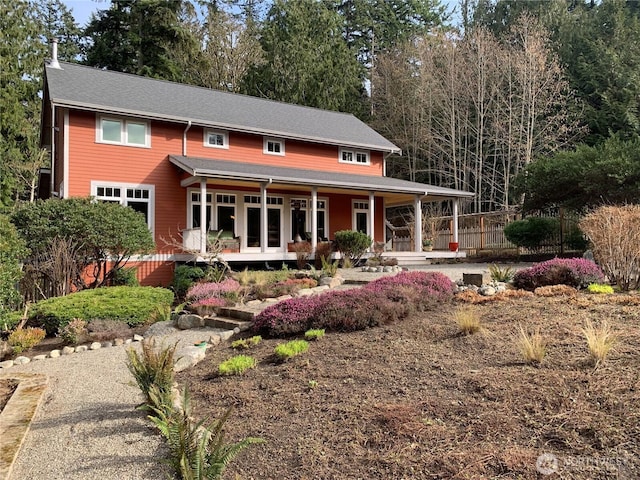 view of front of home with covered porch and fence