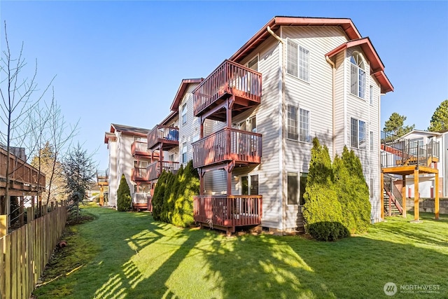 back of house featuring a lawn and a wooden deck