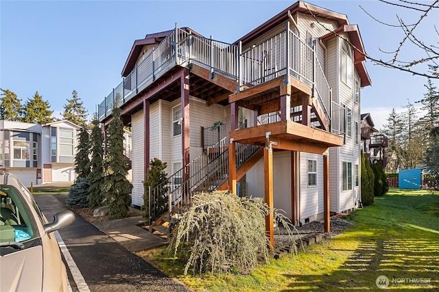 view of property exterior featuring stairway and a lawn