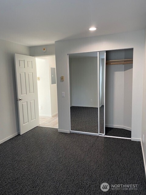 unfurnished bedroom with a closet, recessed lighting, baseboards, and carpet