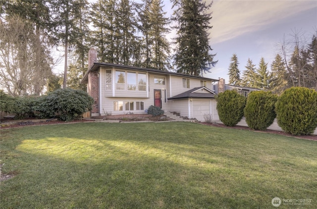 raised ranch featuring brick siding, a chimney, and a front yard