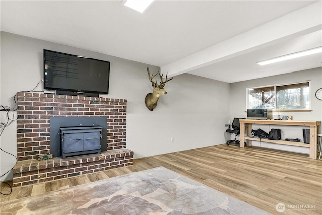 living room with a fireplace, wood finished floors, and beam ceiling