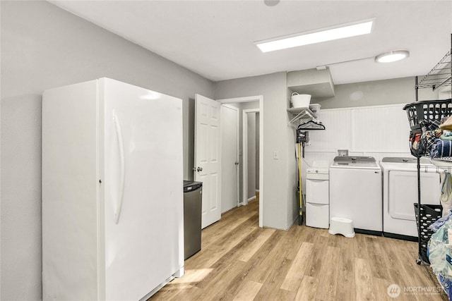 clothes washing area featuring laundry area, light wood finished floors, and independent washer and dryer