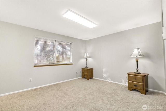 carpeted empty room featuring baseboards