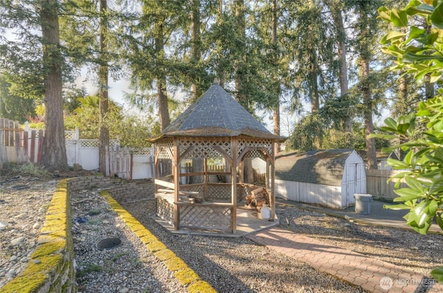 view of jungle gym with an outbuilding, fence, a gazebo, and a storage shed