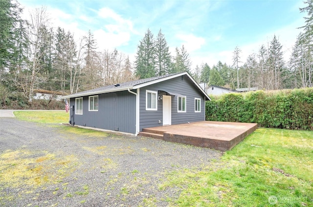 rear view of house featuring a wooden deck, a yard, and crawl space