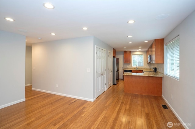 kitchen with visible vents, brown cabinets, light wood-style flooring, recessed lighting, and appliances with stainless steel finishes