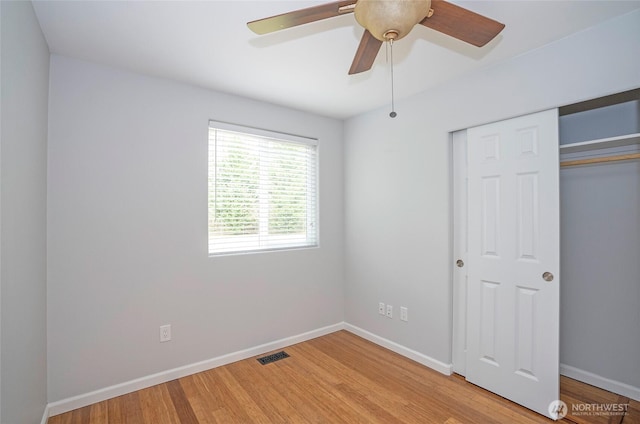 unfurnished bedroom featuring a closet, visible vents, light wood-style flooring, and baseboards