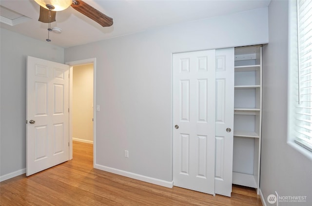 unfurnished bedroom with a closet, a ceiling fan, baseboards, and wood finished floors