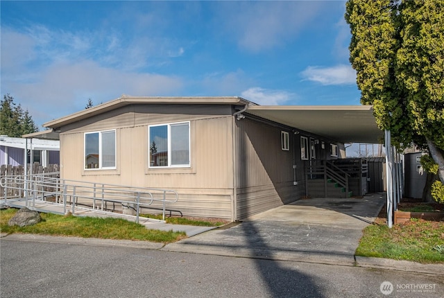 view of front of property featuring aphalt driveway, an attached carport, and fence