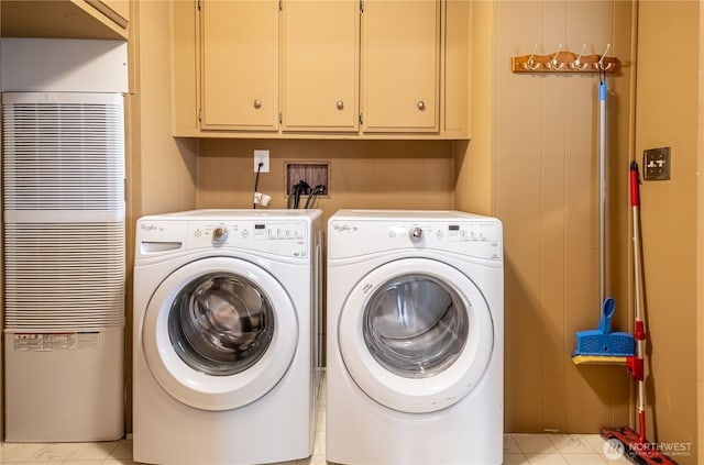 clothes washing area featuring cabinet space, a heating unit, and washing machine and clothes dryer