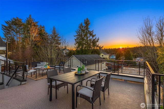 patio terrace at dusk featuring a balcony and an outdoor hangout area