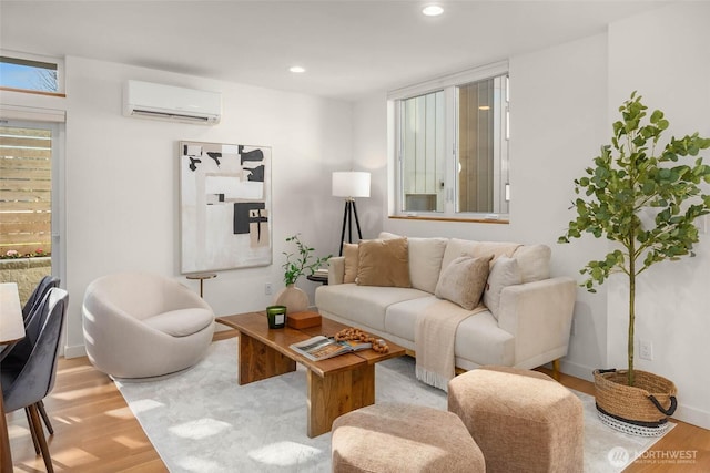 living area featuring recessed lighting, a wall unit AC, baseboards, and wood finished floors