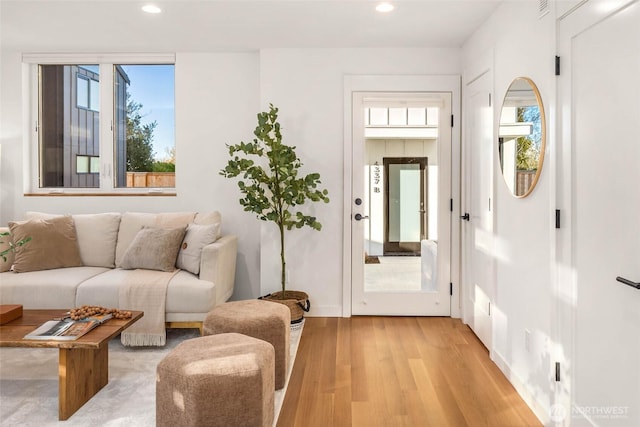 living area featuring light wood-type flooring and recessed lighting