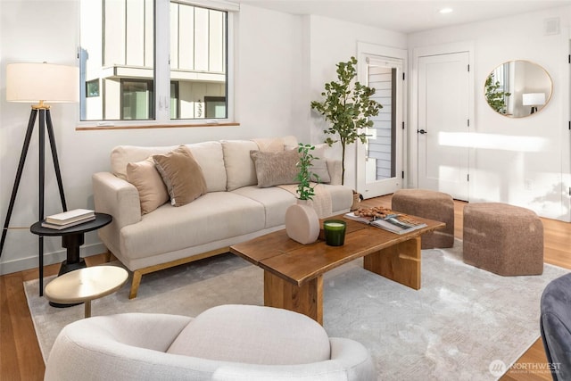 living area with recessed lighting, visible vents, and wood finished floors