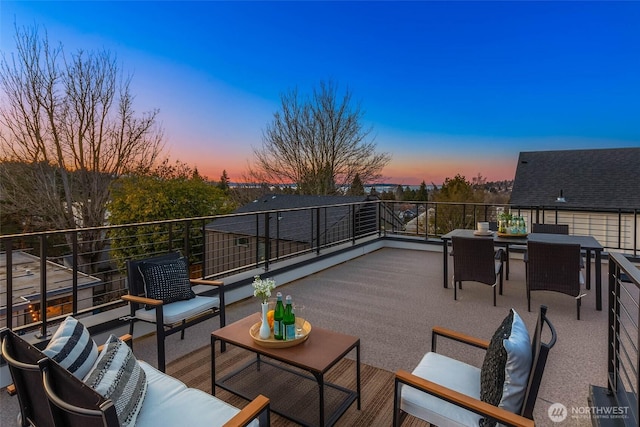 patio terrace at dusk featuring an outdoor living space and a balcony