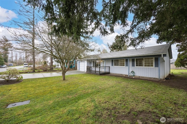 view of front of house with concrete driveway, a garage, and a front yard