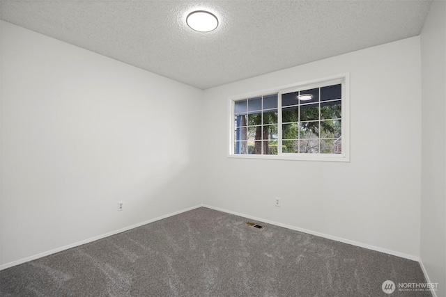 carpeted empty room with visible vents, a textured ceiling, and baseboards