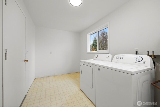 washroom featuring laundry area, washing machine and dryer, and light floors