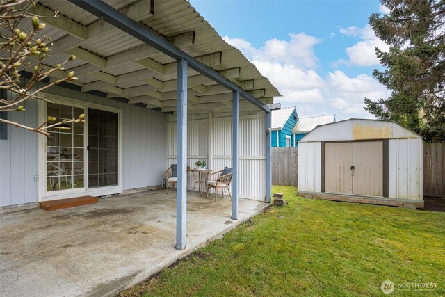 view of yard with a patio, a storage shed, an outdoor structure, and fence