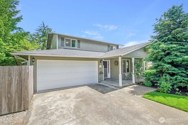 view of front of home featuring driveway, fence, roof with shingles, covered porch, and a garage