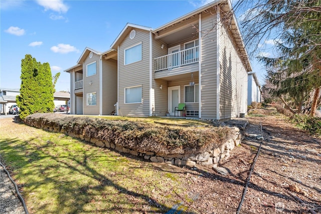 view of front of house featuring a front lawn and a balcony