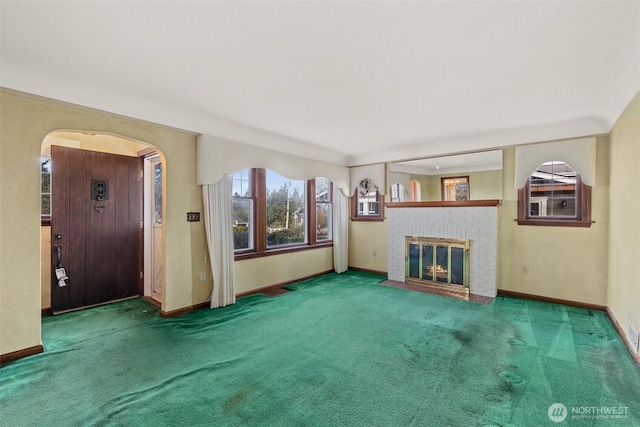 unfurnished living room featuring baseboards, carpet, and a fireplace