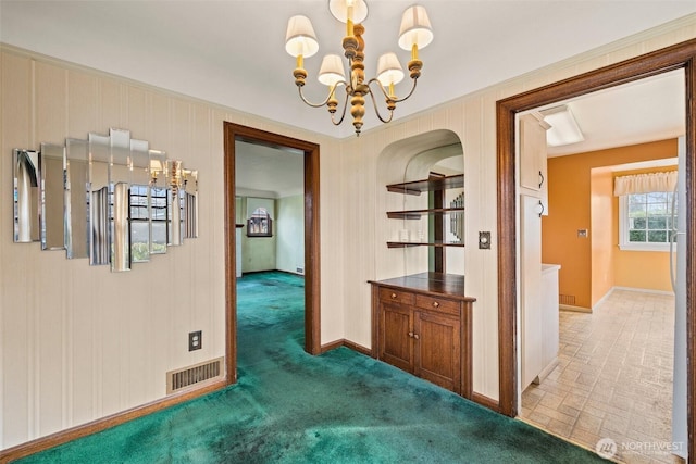 hall featuring baseboards, visible vents, light carpet, and an inviting chandelier