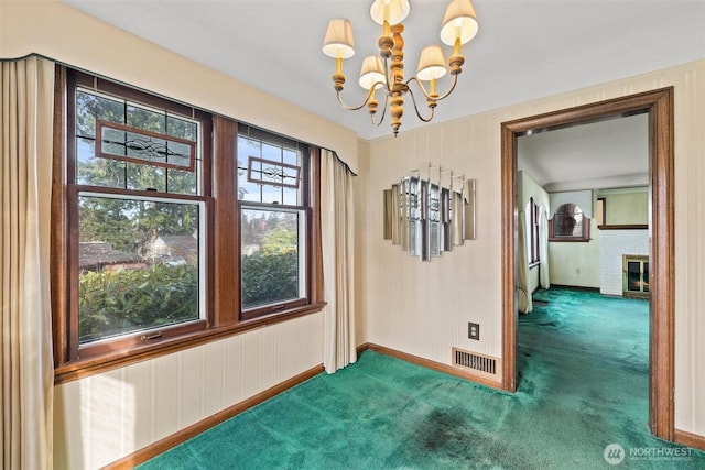 unfurnished dining area featuring visible vents, an inviting chandelier, carpet flooring, baseboards, and a brick fireplace