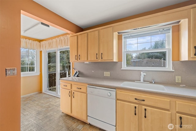 kitchen featuring light brown cabinets, light countertops, decorative backsplash, white dishwasher, and a sink