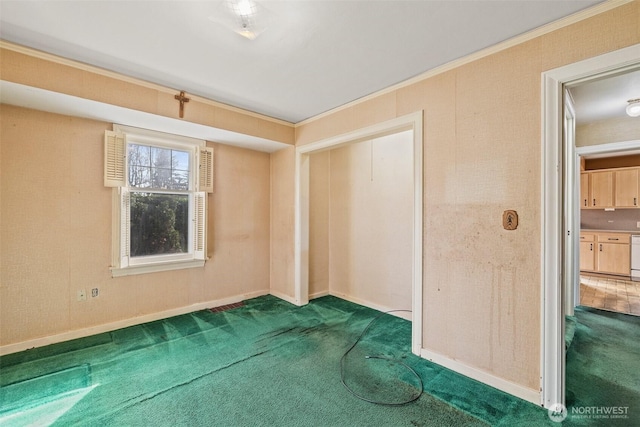 spare room featuring dark colored carpet, baseboards, and ornamental molding