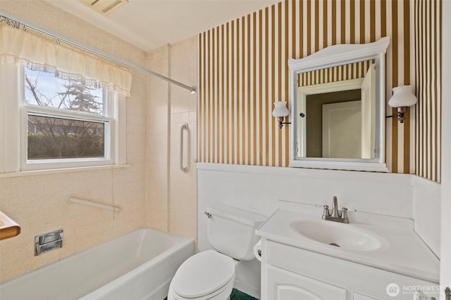 bathroom featuring wallpapered walls, toilet, vanity, and bathtub / shower combination