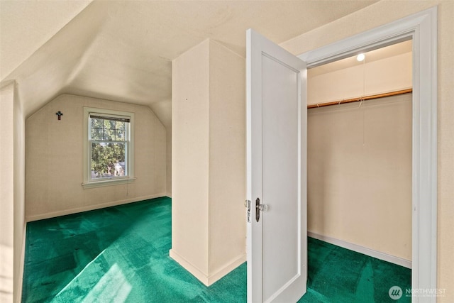 interior space featuring lofted ceiling, carpet, and baseboards