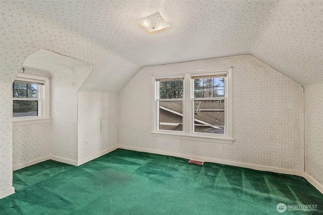 bonus room with a wealth of natural light, vaulted ceiling, and wallpapered walls