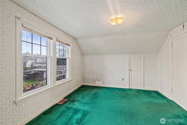 bonus room with visible vents, carpet flooring, wallpapered walls, baseboards, and vaulted ceiling