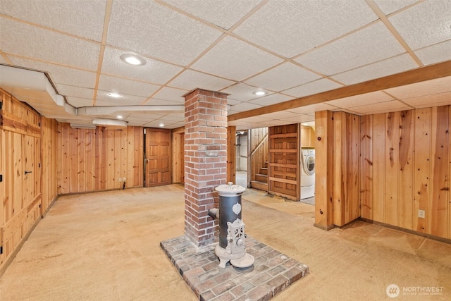 finished below grade area featuring wooden walls, carpet floors, washer / dryer, recessed lighting, and stairs