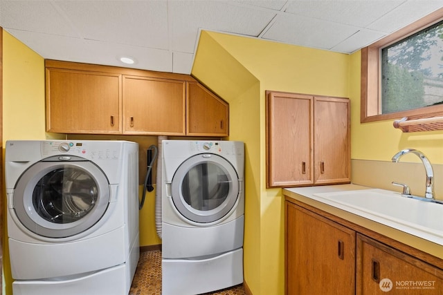 laundry room featuring a sink, cabinet space, and washer and clothes dryer