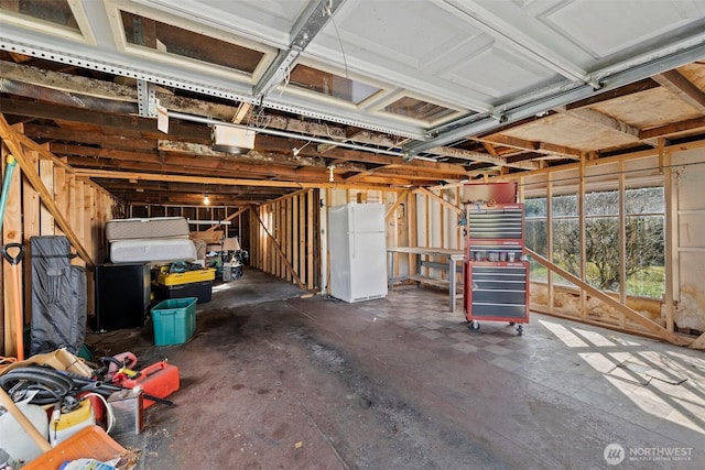 garage featuring a garage door opener and freestanding refrigerator