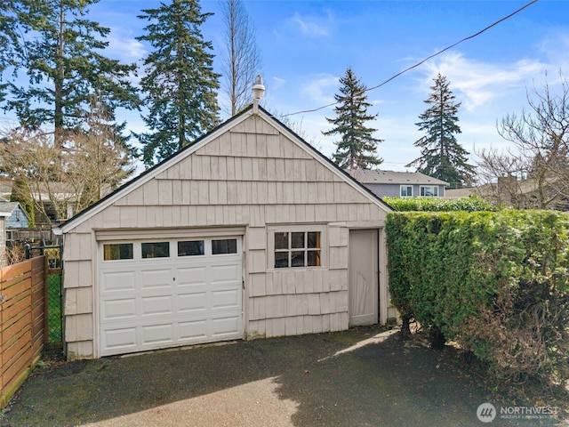 detached garage featuring fence