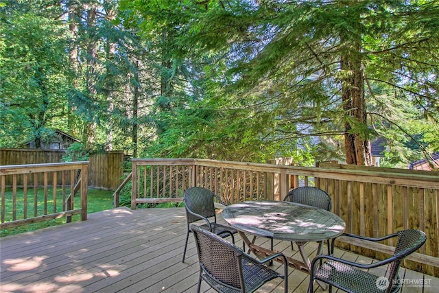 wooden terrace featuring fence and outdoor dining space