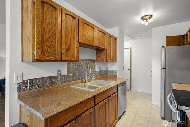 kitchen with light tile patterned floors, stainless steel appliances, a sink, backsplash, and brown cabinetry