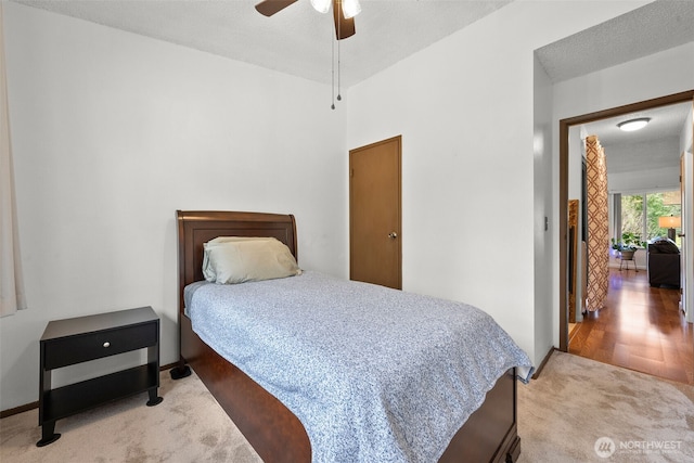 bedroom with a ceiling fan, carpet, a textured ceiling, and baseboards