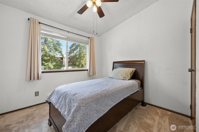 bedroom featuring ceiling fan, a textured ceiling, baseboards, vaulted ceiling, and carpet