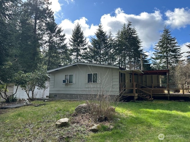 back of property featuring a lawn and a wooden deck