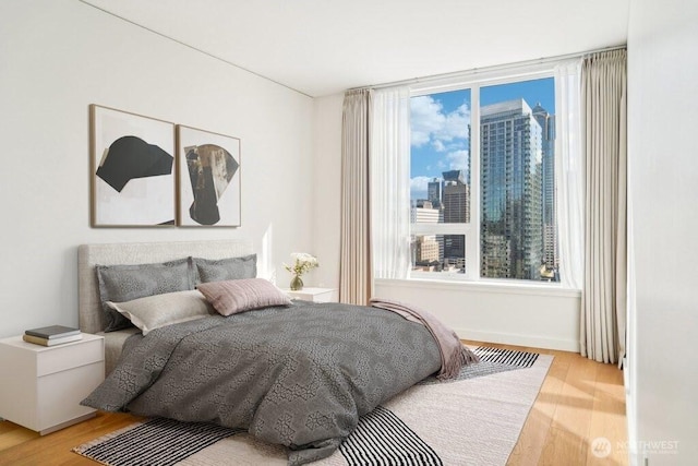 bedroom featuring a city view and light wood finished floors