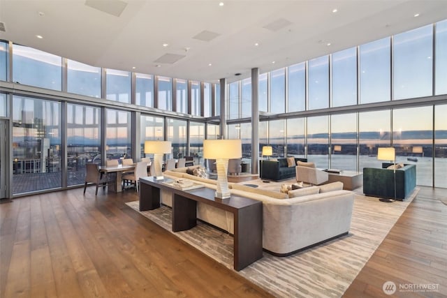 living area with floor to ceiling windows and hardwood / wood-style floors