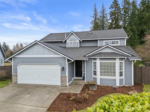 traditional home featuring brick siding, a shingled roof, fence, a garage, and driveway